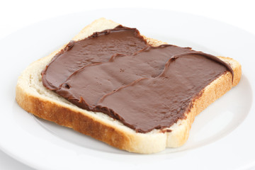 Wall Mural - Chocolate nut spread on sliced white bread on plate.