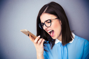 Canvas Print - Angry businesswoman shouting on smartphone