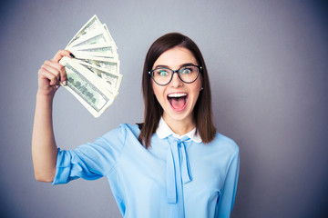 Laughing businesswoman holding bills of dollar