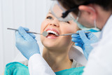 Fototapeta  - Regular dentist visit. Caries cure. Young woman visiting dentist