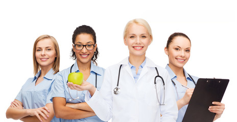 Canvas Print - smiling female doctor and nurses with green apple