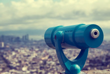 Blue Telescope And Blurred City On Background.