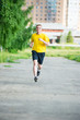 © mr.markin - Sporty man jogging in city street park. Outdoor fitness.