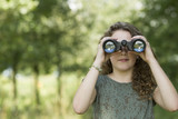 Fototapeta Młodzieżowe - Pretty young girl exploring the environment with a binocular