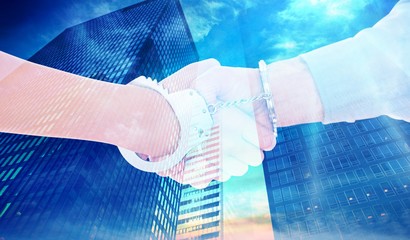 Composite image of handcuffed business people shaking hands