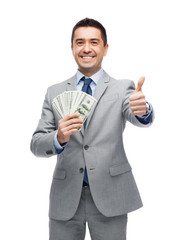 Wall Mural - smiling businessman with money showing thumbs up