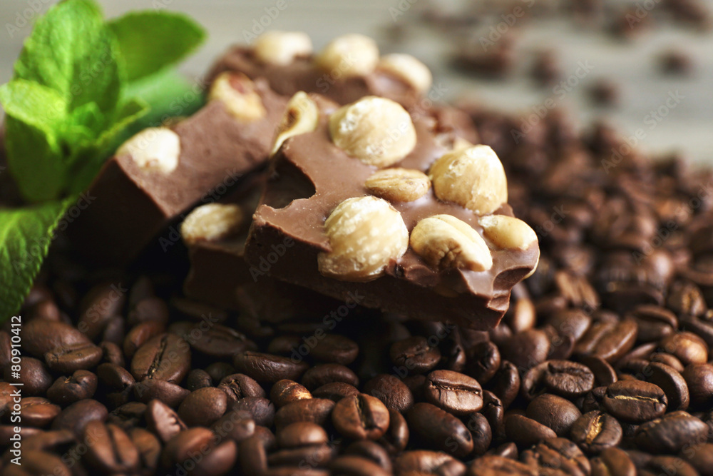 Chocolate with mint and coffee beans on wooden table, closeup
