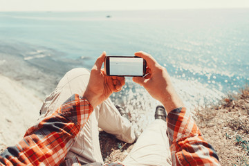 Wall Mural - Traveler taking photographs sea with smartphone