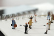 © everythingpossible - close up of miniature people with social network diagram on open