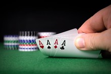 A Poker Hand Of Four Aces With Chips And Copy Space Background