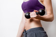 © Masson - Woman showing her abs with dumbbell