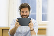 © ldprod - Man in office withe tablet pc and headphones
