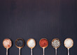 Salt in vintage metal spoons on a wooden background