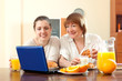 © JackF - Two happy women using laptop during breakfast