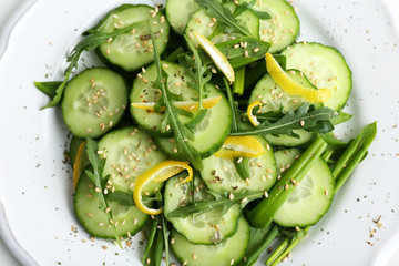 Wall Mural - Green salad with cucumber, arugula and lemon peel, closeup