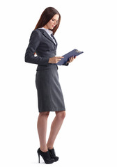 Attractive young businesswoman standing near desk with folder in