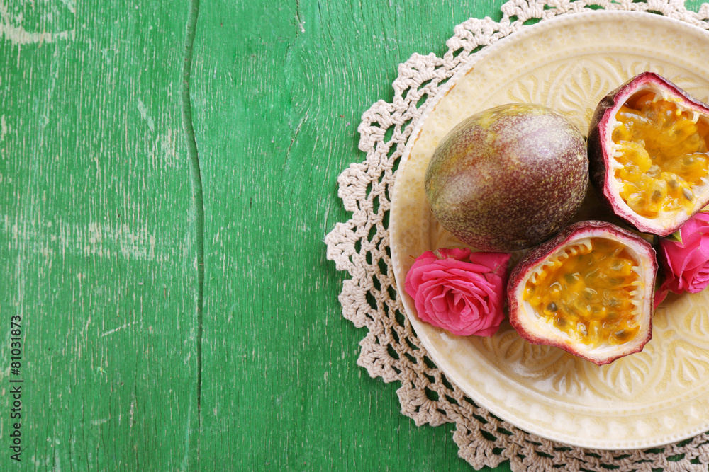Passion fruit on plate on color wooden background