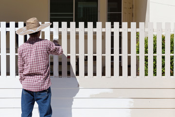 Wall Mural - worker painted white fence with brush