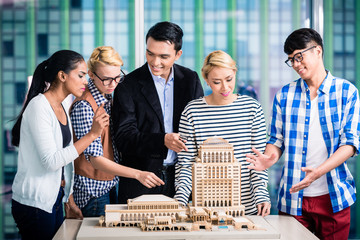 Wall Mural - Team of architects presenting model building