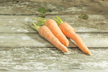 Bunch of fresh carrots on wooden table.