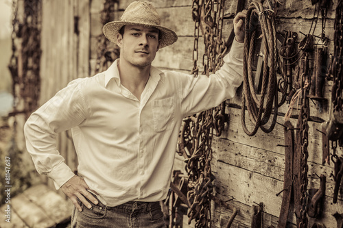 Fotografia Farmer Portrait in front of a Wall Full of Tools