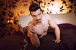 © sakkmesterke - Sexy macho man laying on bed with handcuffs