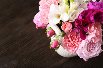 Poster - Beautiful spring flowers in pot on wooden background