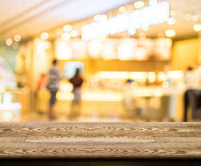 Wall Mural - empty wood table top with coffee shop blur with bokeh background