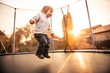 © Martinan - Child jumping trampoline at sunset