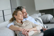 Mature couple sitting in sofa, looking away
