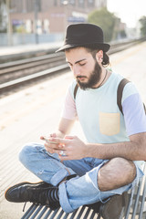 Wall Mural - young handsome hipster gay modern man using smartphone