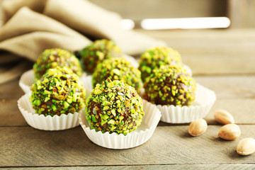 Poster - Tasty homemade pistachio candies on wooden table