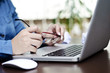 © psphotography - a young woman holding her glasses while working on computer
