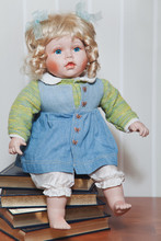 Vintage Porcelain Doll Blonde Sitting On Stack Of Books