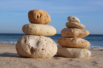 two stack of pebble on sandy beach