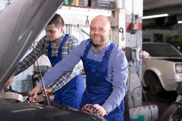 Two car mechanics at workshop