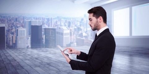 Poster - Composite image of concentrated businessman touching his tablet