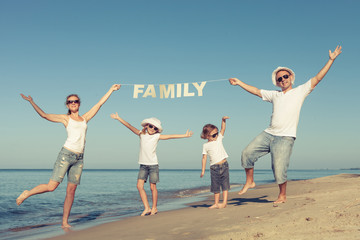 Wall Mural - Happy family standing on the beach at the day time.