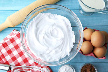 Wall Mural - Whipped egg whites for cream on wooden table, top view