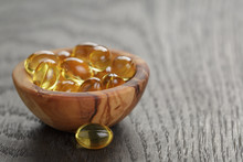 Fish Oil Capsules In Wood Bowl On Wooden Table