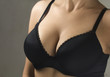 Woman wearing a black brassiere isolated on a gray background