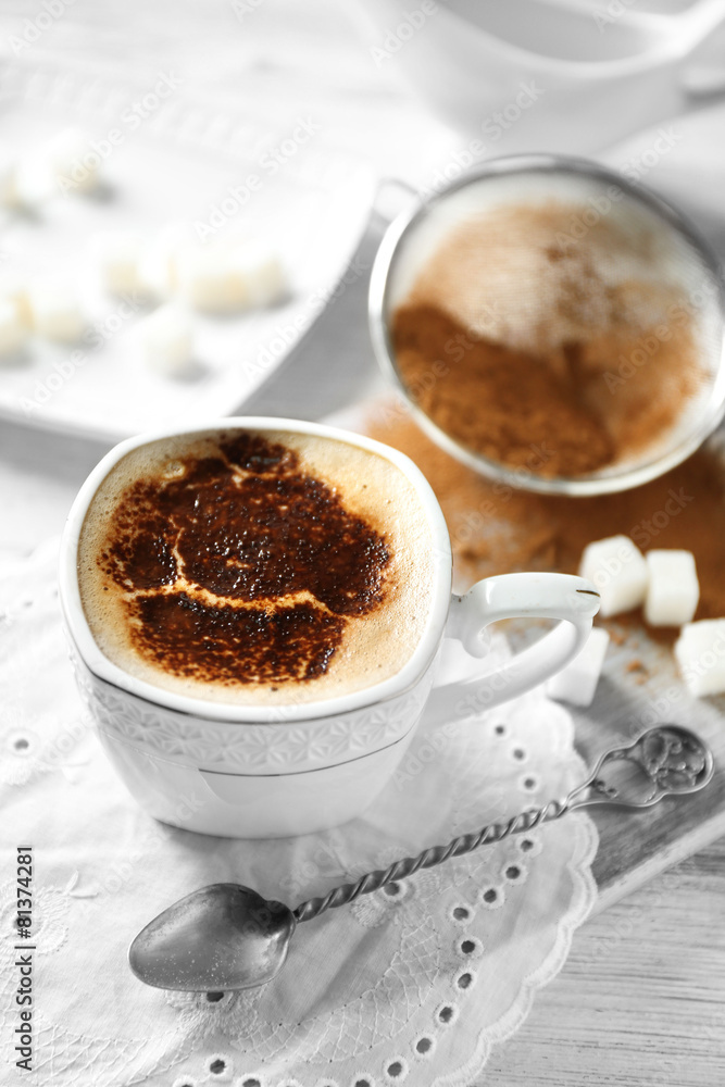 Cup of latte coffee art on wooden table, on light background