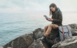 © Alex Photo - Traveler woman sitting on coast with digital tablet