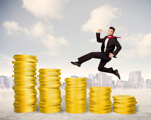 Successful business man jumping up on gold coin money