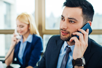 close up of a young business man who talks on the phone