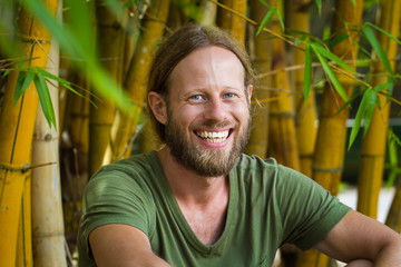 Portait of a relaxed happy man in a bamboo garden