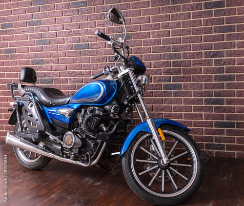 Naklejka dekoracyjna Blue motorbike parked in front of a brick wall