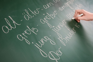 Wall Mural - Teacher hand writing grammar sentences on blackboard background