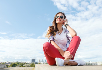 smiling teenage girl in eyeglasses with headphones