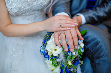 Hands Of The Bride And Groom With The Rings Lying On The Bridal